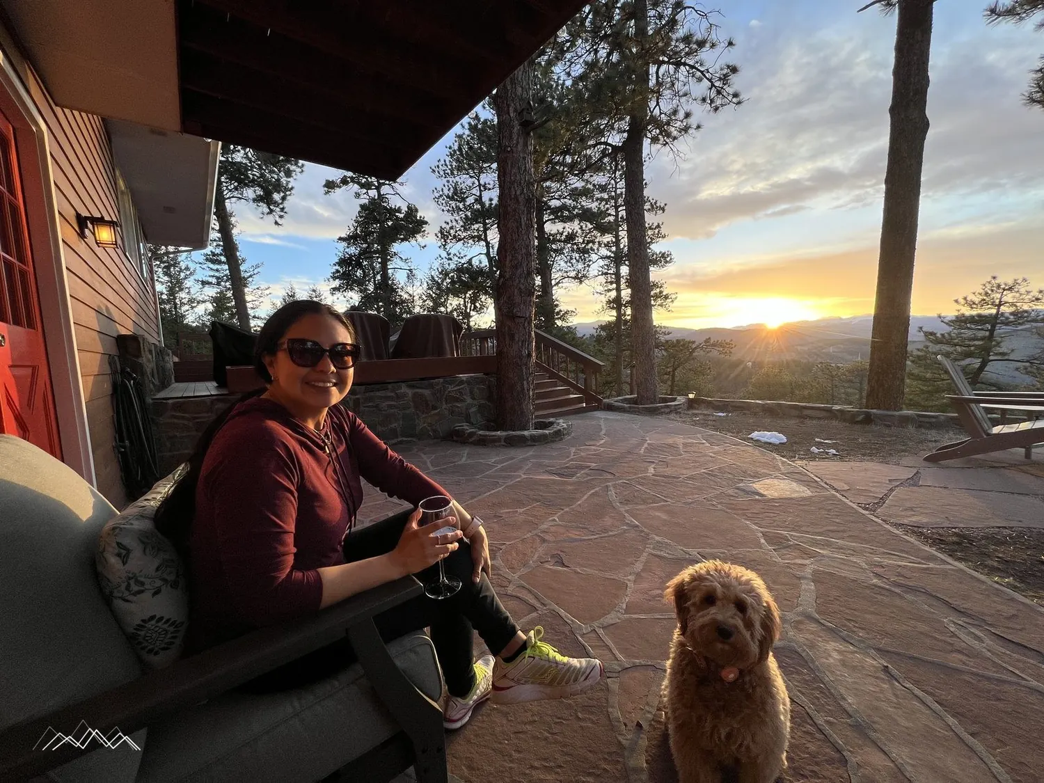 Mily relaxing with a glass of wine and the dog on the patio at sunset